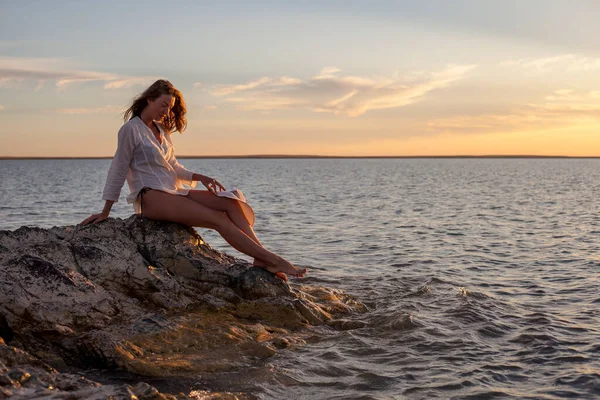 Vacker Kvinna Njuter Solnedgången Stranden Sitter Stenar — Stockfoto