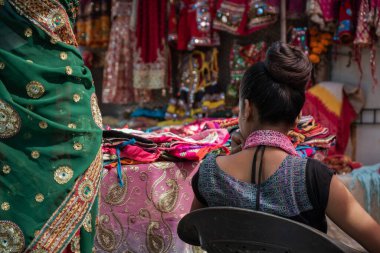 Piyasada, Goa 'da, Hindistan' da sari satan bir kadının arka görüntüsü.