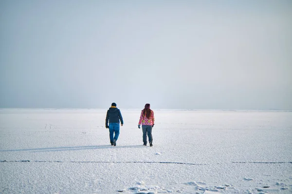 冬日里 一个男人和一个姑娘在冰封的湖面上散步 — 图库照片