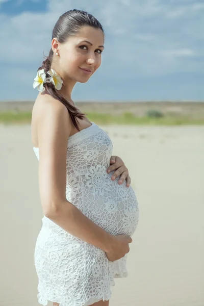 Gravid kvinde i hvid badedragt - Stock-foto