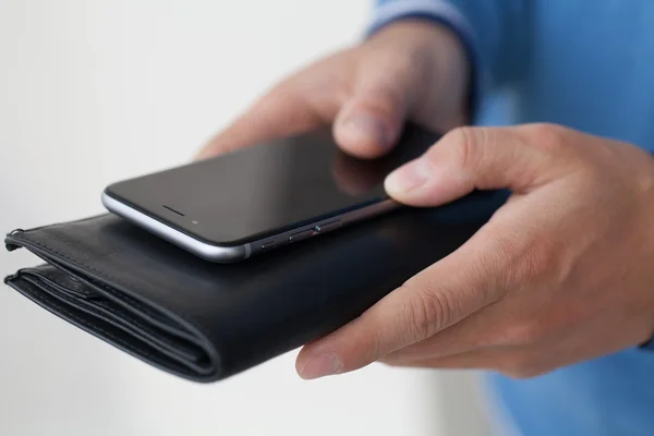 Закрытый черный кошелек и мобильный телефон — стоковое фото