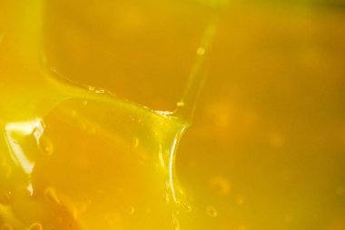 Bal kaşıktan akar, güneş ışığını yakalar ve parlak bir görüntü yaratır. Bu sahne balın dokusunu ve rengini gösteriyor..