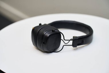 Modern kulaklıklar temiz, beyaz bir yüzey üzerinde dinleniyor. Ses, teknoloji veya rahatlama kavramlarını temsil etmek için ideal