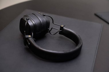 Koyu bir yüzeyde duran zarif siyah kulaklıklar, kaliteli tasarım ve kaliteyi gösteriyor. Yaşam tarzı ve ürün tasviri için ideal