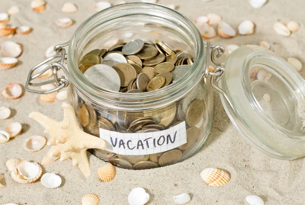 Ahorro para vacaciones. Monedas y conchas en la playa — Foto de Stock