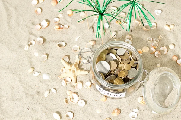 Risparmio per le vacanze. Monete e conchiglie in spiaggia — Foto Stock