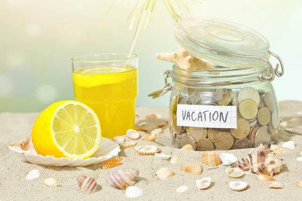 Ersparnisse für den Urlaub. Münzen und Muscheln am Strand — Stockfoto