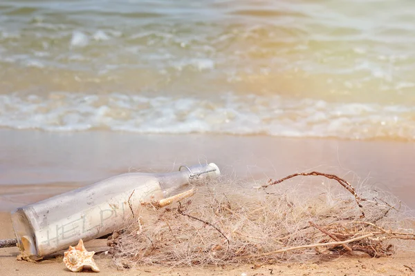 Una bottiglia con un messaggio sulla spiaggia del mare . — Foto Stock