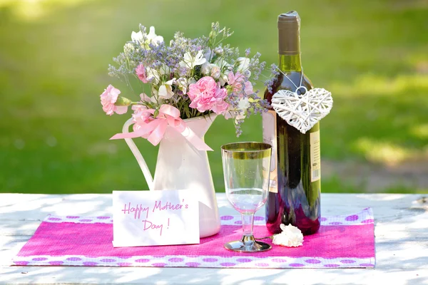 Glas vin på ett bord i trädgården på en solig dag — Stockfoto