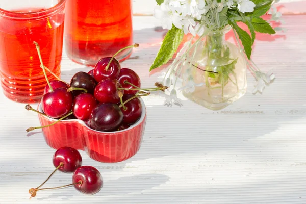 Cerejas doces em uma caixa de coração na mesa de madeira no jardim — Fotografia de Stock