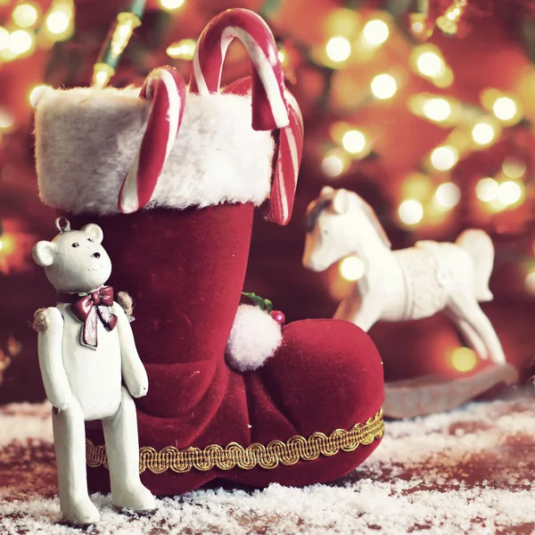 Stiefel, Schaukelpferd und Teddybär auf weihnachtlichem Hintergrund — Stockfoto