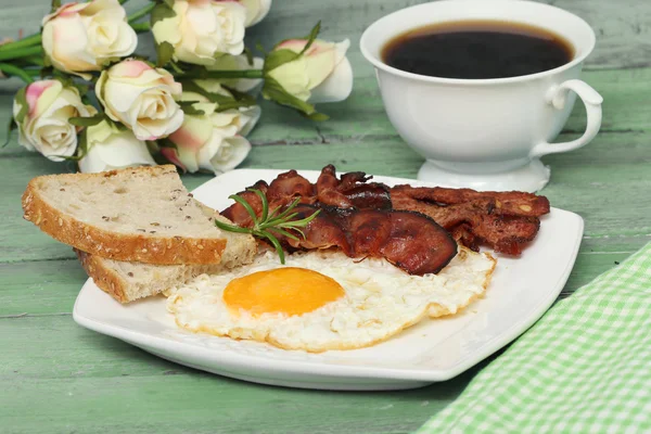 Fried eggs with bacon on the wooden table — Stock Photo, Image