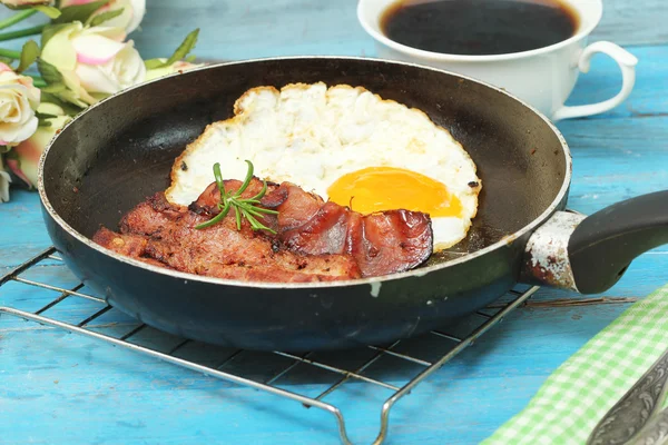 Fried eggs with bacon on the wooden table — Stock Photo, Image