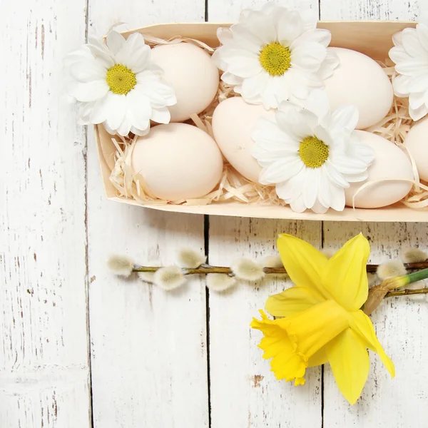 Uova di Pasqua con fiori su sfondo di legno — Foto Stock