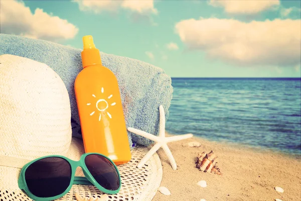 Ψάθινο καπέλο, γυαλιά ηλίου, πετσέτα και αστερίες σε παραλία με άμμο. — Φωτογραφία Αρχείου