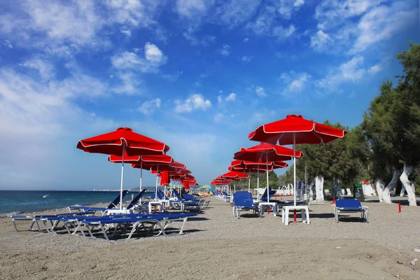 Red umbrellas on the beach. Greece, Rhodes — Stock Photo, Image