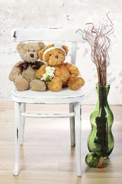 Dois ursos de peluche apaixonados sentam-se numa cadeira. Conceito de casamento — Fotografia de Stock