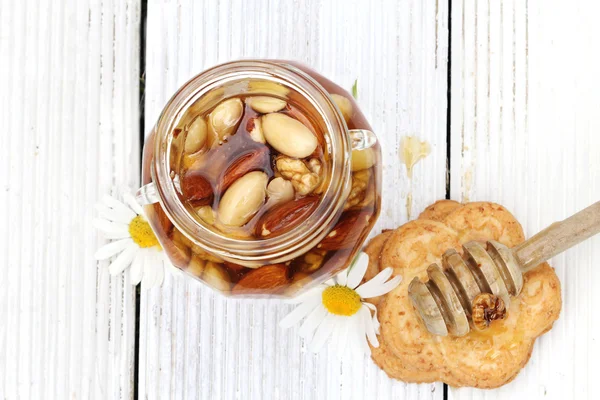 Honey in glass jars with flowers — Stock Photo, Image