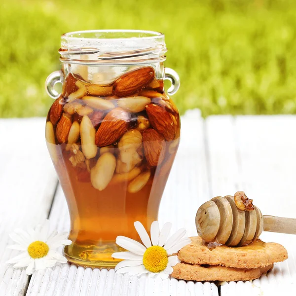 Honey in glass jars with flowers — Stock Photo, Image