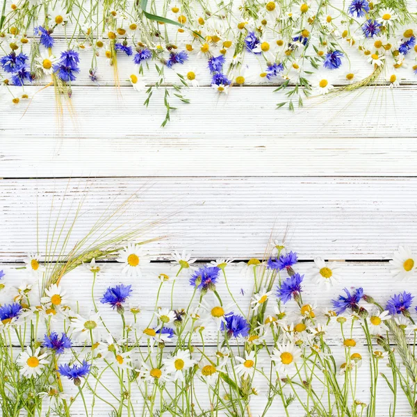 Letní květy a žito na dřevěné pozadí — Stock fotografie