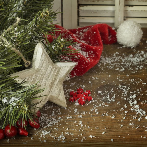 Pohon cemara Natal dengan topi merah dan salju di latar belakang kayu — Stok Foto