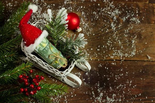 Geschenkgeld mit roter Schleife und Weihnachtsmütze — Stockfoto