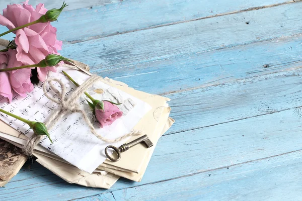 Rosa Rose, Herz und alte Buchstaben auf romantischem blauem Hintergrund — Stockfoto