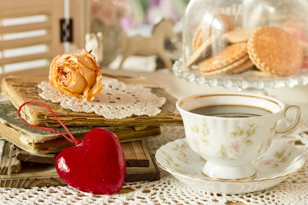 Droge rose op een oud boek, hart en schommelpaard in een vintage s — Stockfoto