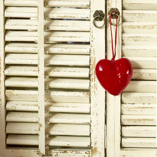 Rotes Holzherz hängt am alten rustikalen Fenster — Stockfoto