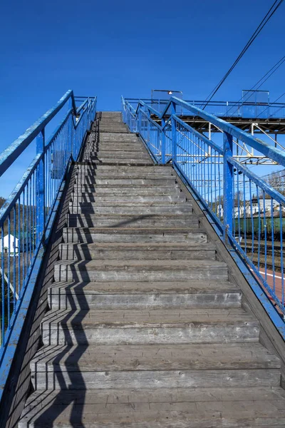 Stairs to the pedestrian crossing over the access roads at railway station, against  cloudless sky