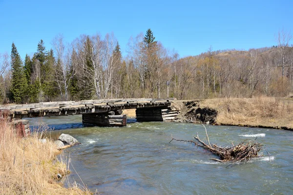 Wooden bridge over the turbulent river — Stock Photo, Image