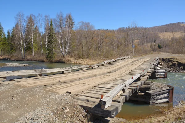 Wooden bridge over the turbulent river — Stock Photo, Image