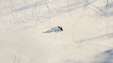 Hava manzaralı karlı gölde bisiklet süren bir adam
