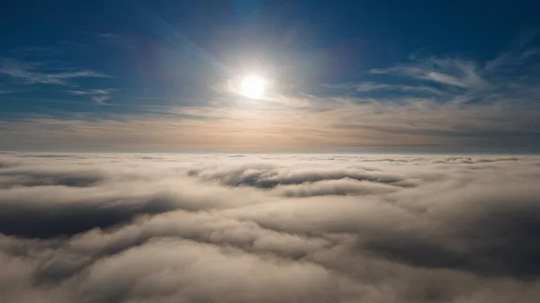 Schöner Abendhimmel über Wolken mit dramatischem Licht. Kabinenblick aus dem Flugzeug lizenzfreie Stockbilder