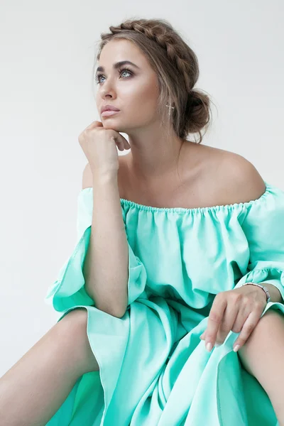 Portrait of beautiful woman with makeup and hairstyle in a turquoise dress — Stock Photo, Image