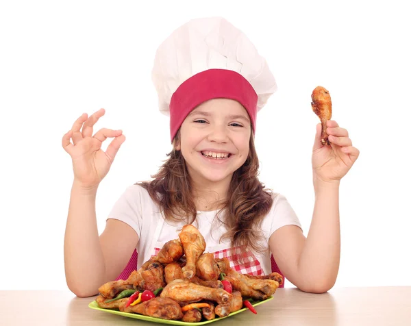 Heureuse petite fille cuisinier avec ok signe de main et pilon de poulet — Photo
