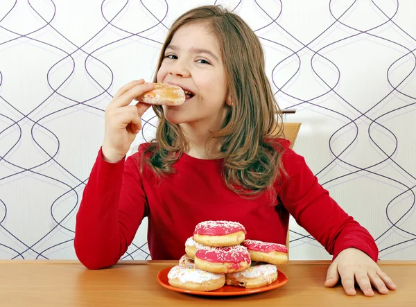 空腹の少女は、甘いドーナツを食べる — ストック写真