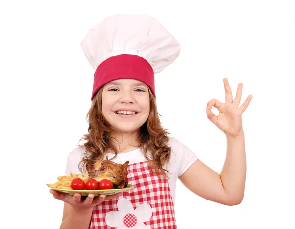 Happy little girl cook with roasted chicken wings and ok hand si — Stock Photo, Image