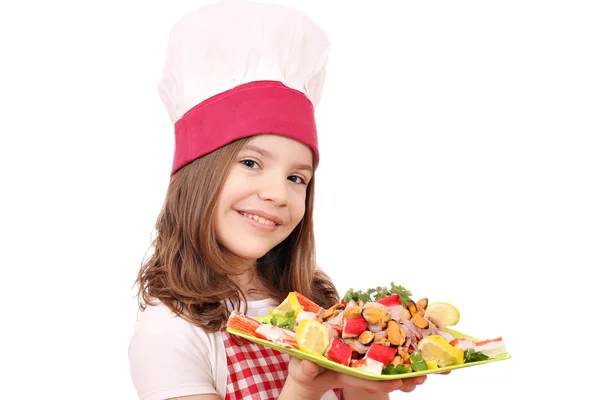 Heureuse petite fille cuisinier avec des fruits de mer — Photo
