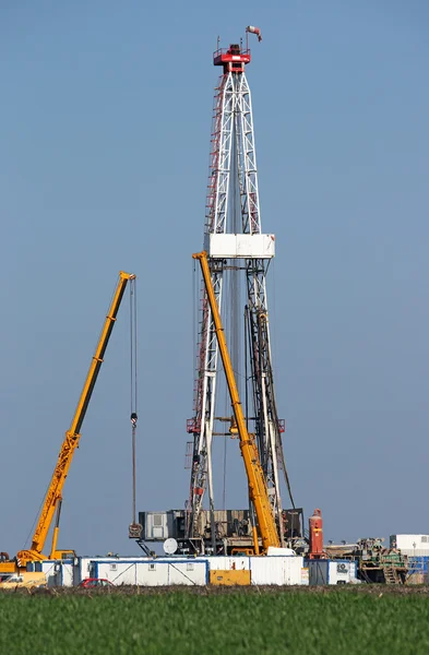 Olie drilling rig en kranen op olieveld — Stockfoto