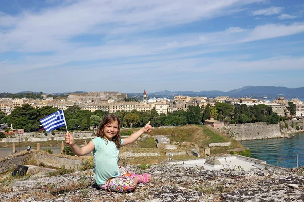 Niña con bandera griega y pulgar hacia arriba Corfú ciudad Grecia — Foto de Stock