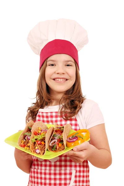 Happy little girl cook with tacos on plate — Stock Photo, Image