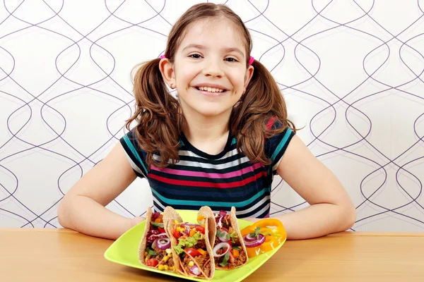 Lycklig liten flicka med tacos på tallrik — Stockfoto