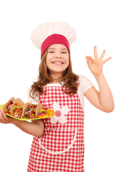 Feliz niña cocinero con tacos y ok mano signo — Foto de Stock