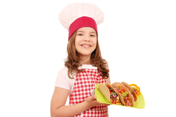 Glückliches kleines Mädchen kocht mit Tacos auf Teller — Stockfoto