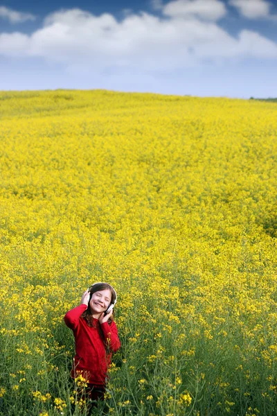 幸せな小さな女の子で音楽を聞いてフィールド夏シーズン — ストック写真