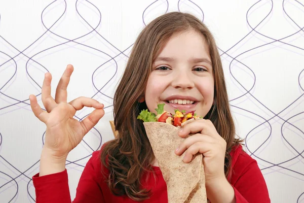 Happy little girl with burritos and ok hand sign — Stock Photo, Image