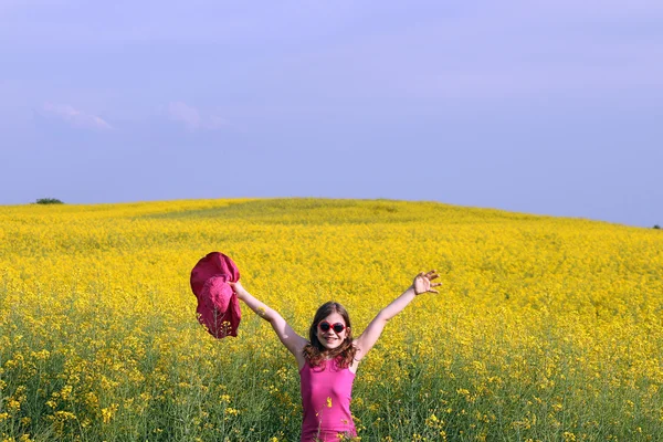 Glückliches kleines Mädchen mit Händen nach oben auf dem Feld Sommer — Stockfoto