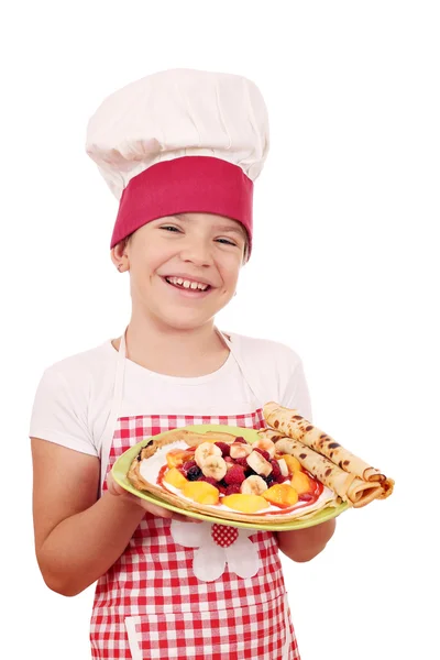 Menina feliz cozinhar com crepes no prato — Fotografia de Stock