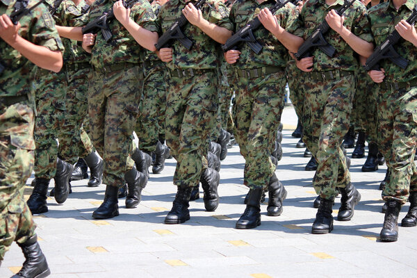 Soldiers with camouflage uniforms marching with rifles